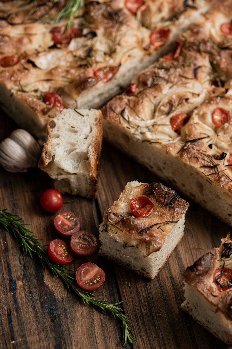 Focaccia con tomates cherry y romero sobre madera